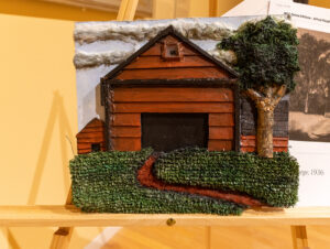 An image of a red barn and tree was created using textured materials that can be felt 