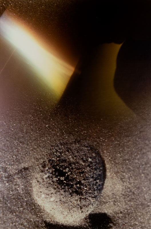 Judith McWillie's abstract photograph "Symbiosis," which features what look like ash-coated forms and a shaft of light from the upper left corner.