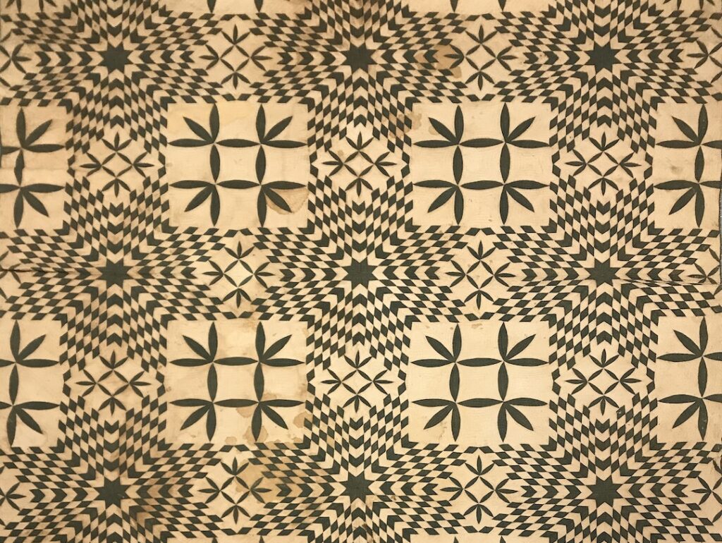 A detail of a quilt created by an enslaved person or persons, with a complex pattern in black and white.