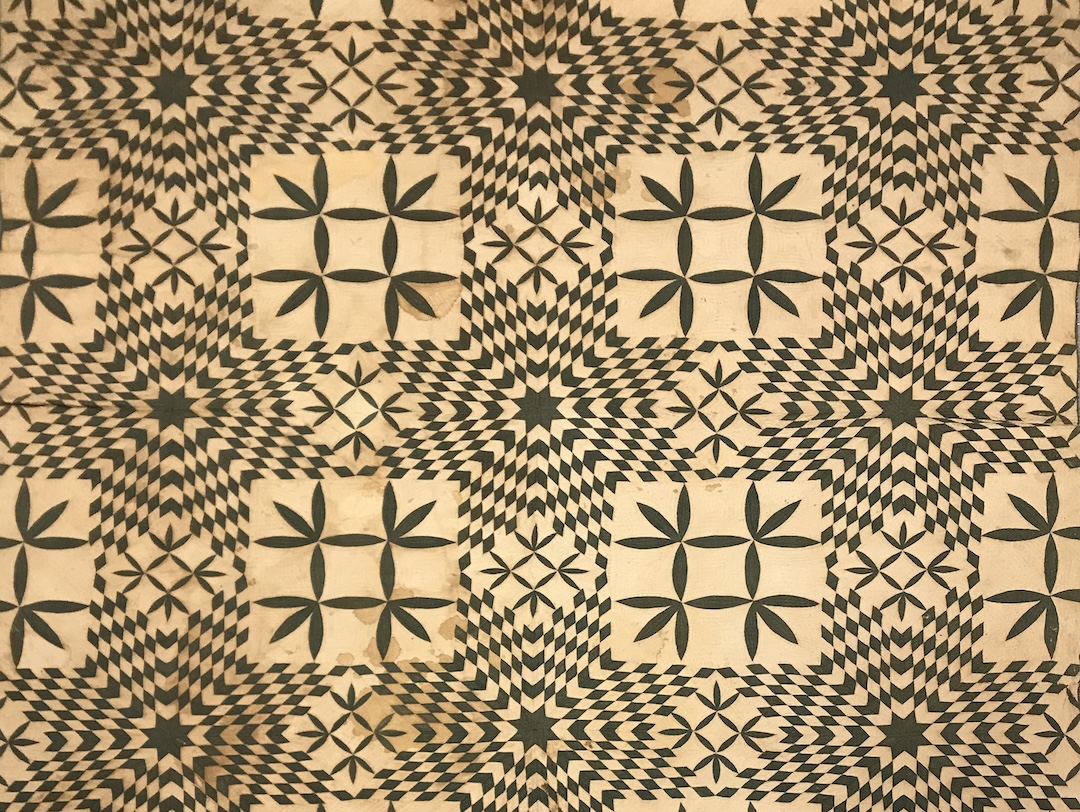 A detail of a quilt created by an enslaved person or persons, with a complex pattern in black and white.