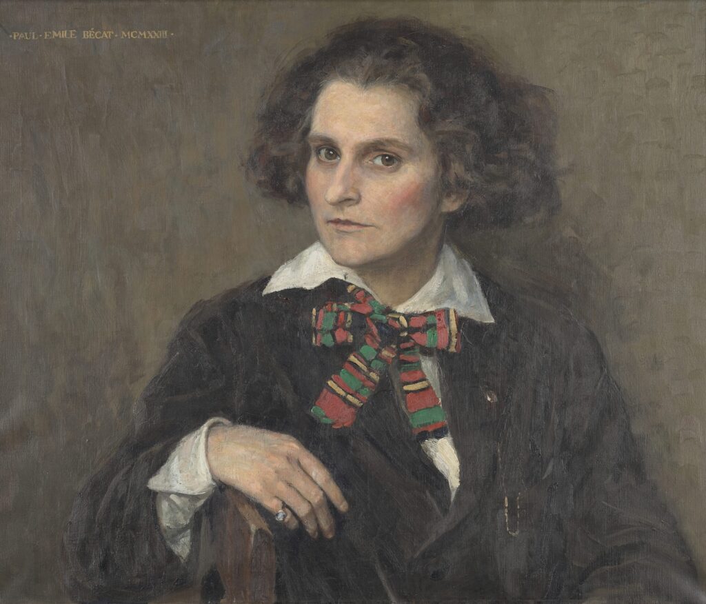 An oil portrait of Sylvia Beach (publisher) from 1921, by Paul-Emile Bécat. She folds her right arm across the back of the chair she sits in. Her hair is dark, wavy, and short, and she wears a dark suit jacket, a white dress shirt and a tartan bowtie at her neck.