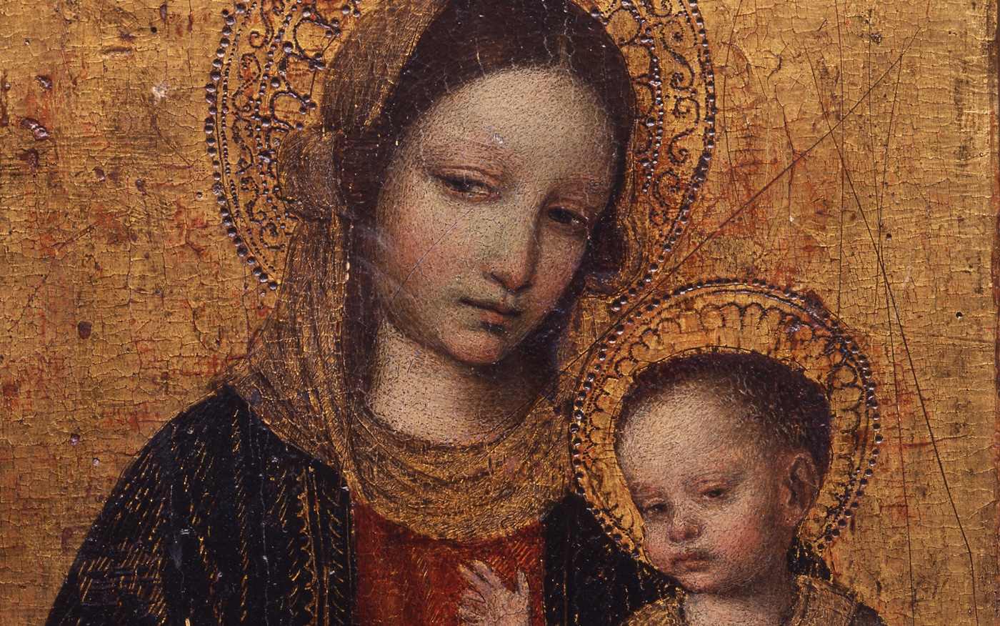 A detail of Ambrogio Borgognone's painting "Madonna and Child," from the 1490s. Mary holds her son Jesus in her lap. Their faces are painted realistically, but their halos appear in gold against a gold background.
