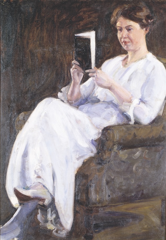 Self-portrait of Lucy May Stanton sitting in an armchair and reading a book