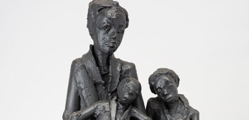 A detail of William Bradley Taylor's "After Daycare," a rough welded steel sculpture that shows a Black woman and her two young children sitting on a bench