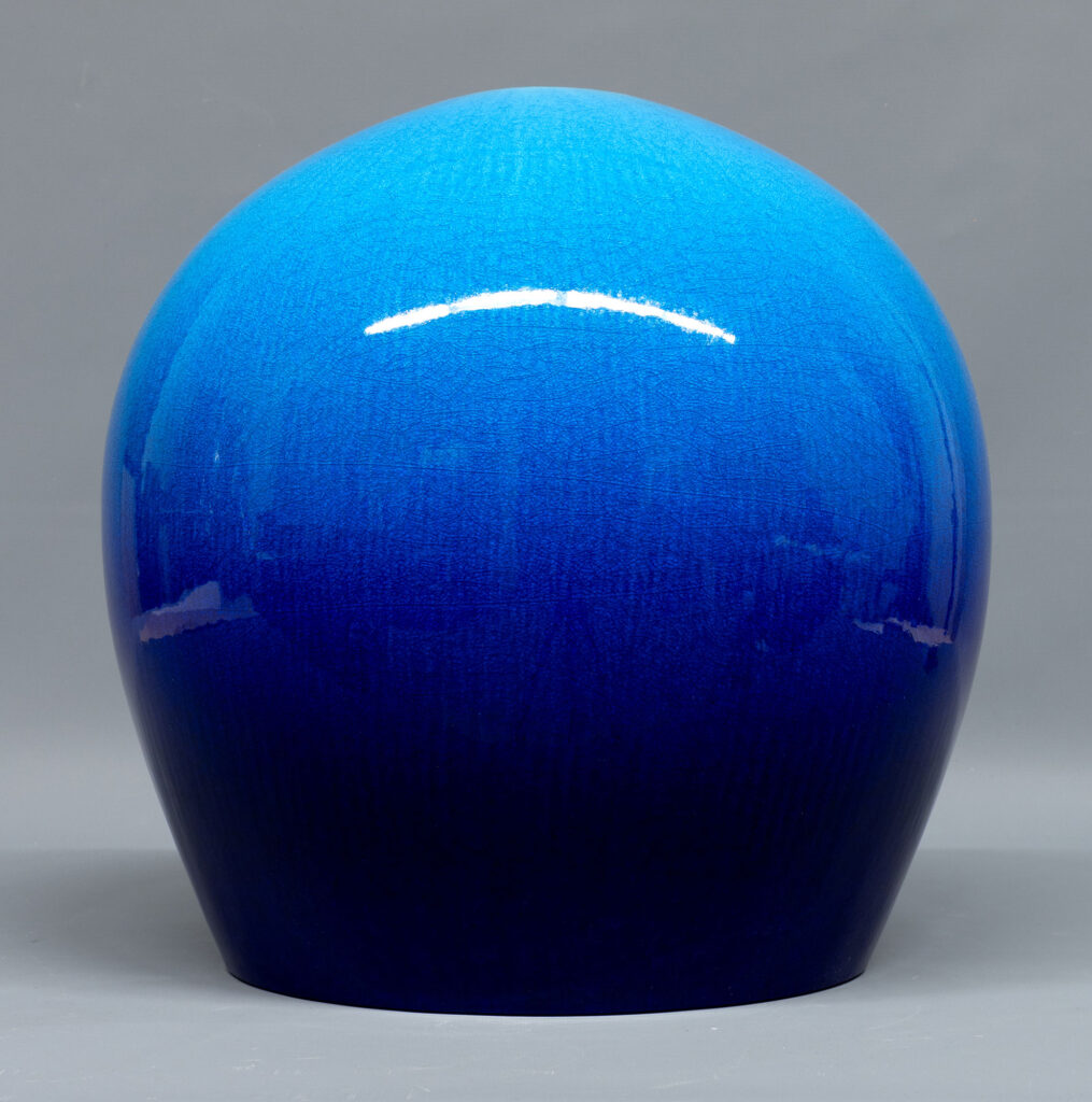 An orb-shaped sculpture in ceramic, glazed in shiny blue, by Kimura Yoshiro
