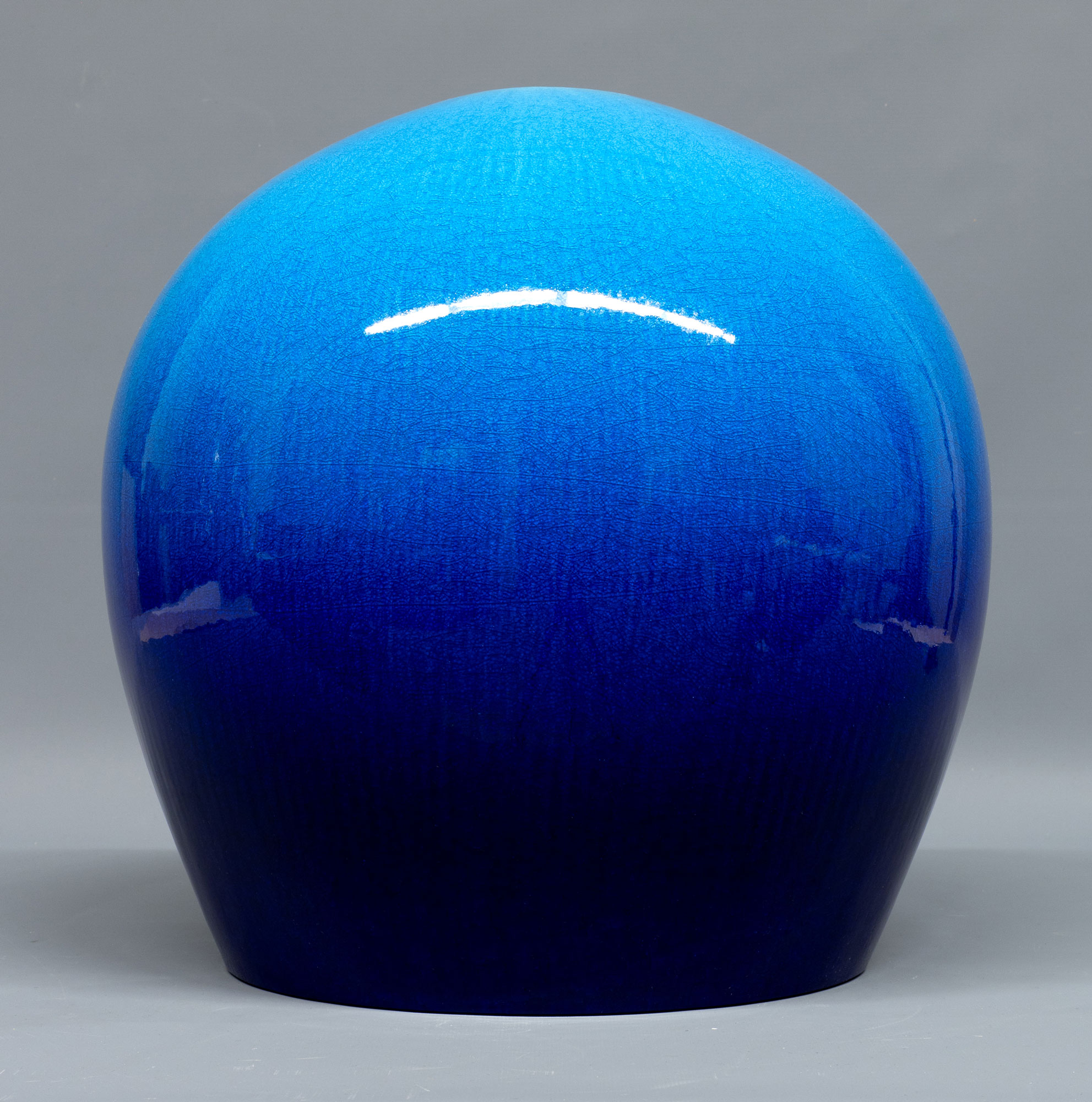 An orb-shaped sculpture in ceramic, glazed in shiny blue, by Kimura Yoshiro