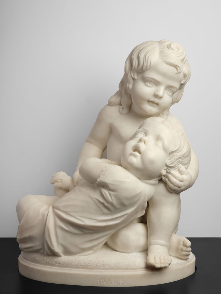 A small marble sculpture by Edmonia Lewis that features a child cradling an infant in its arms