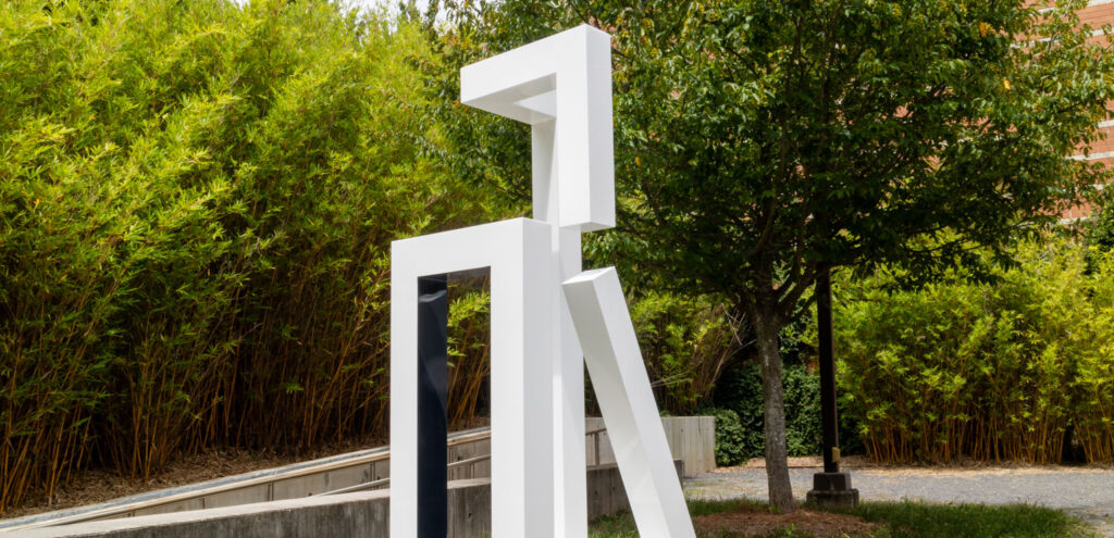 Jane Manus' geometric aluminum sculpture, painted white, titled "Not Yet," installed in the museum's sculpture garden
