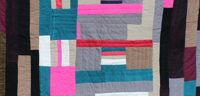 A detail of a quilt by Mary Lee Bendolph featuring stripes and rectangular shapes in blue, gray, brown, and then pops of hot pink and red
