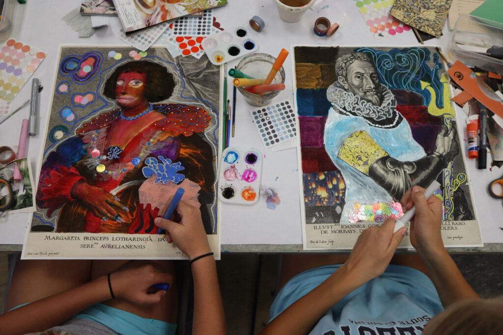 A photograph over the shoulder of two teenagers making their own art at Teen Studio