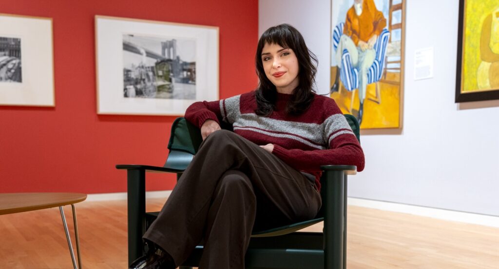 Visitor services assistant Ari Engle relaxes in a chair in the museum's Swanson Gallery.