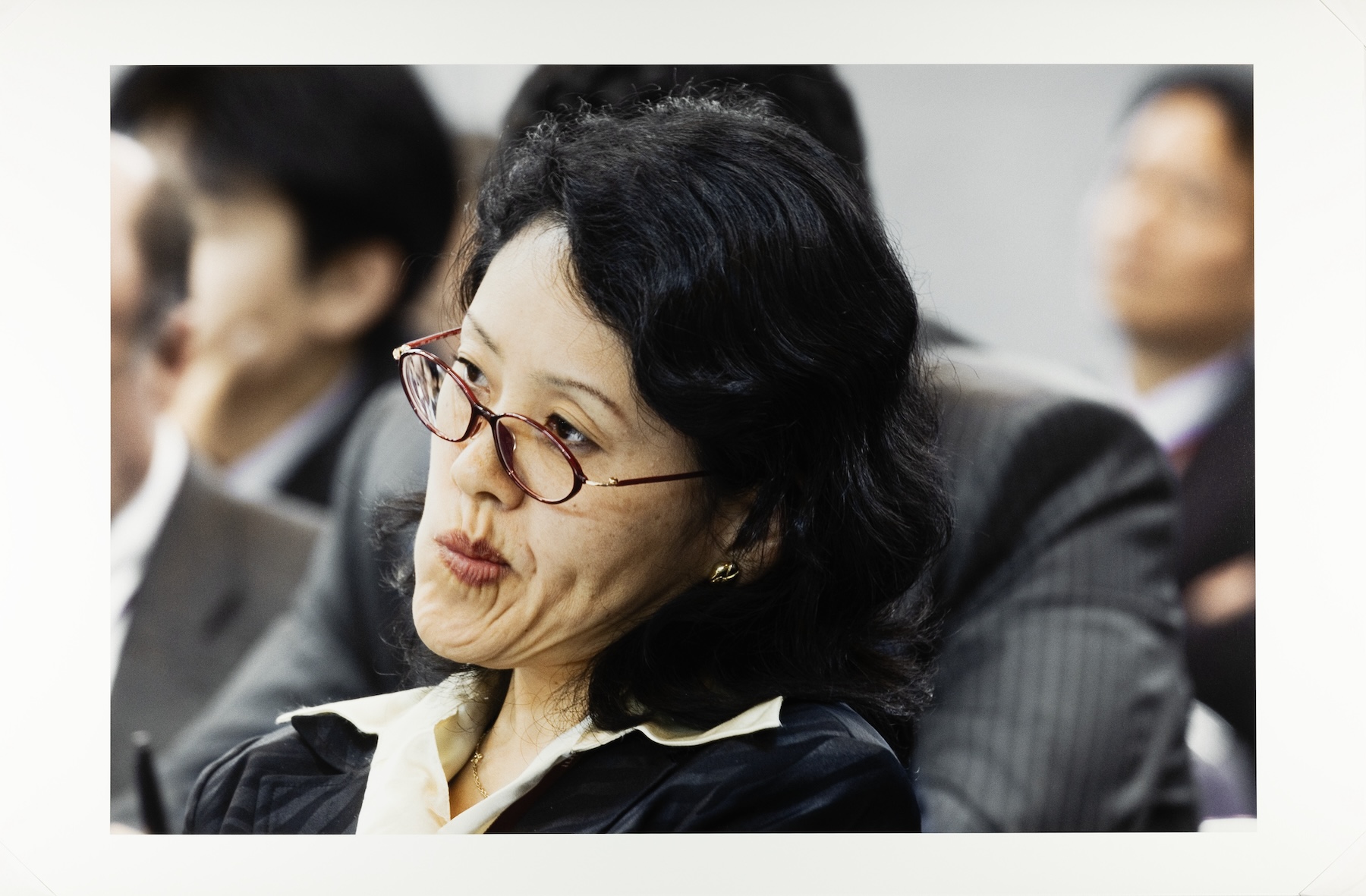 Japanese woman pursing her lips to the side while hearing concerning news