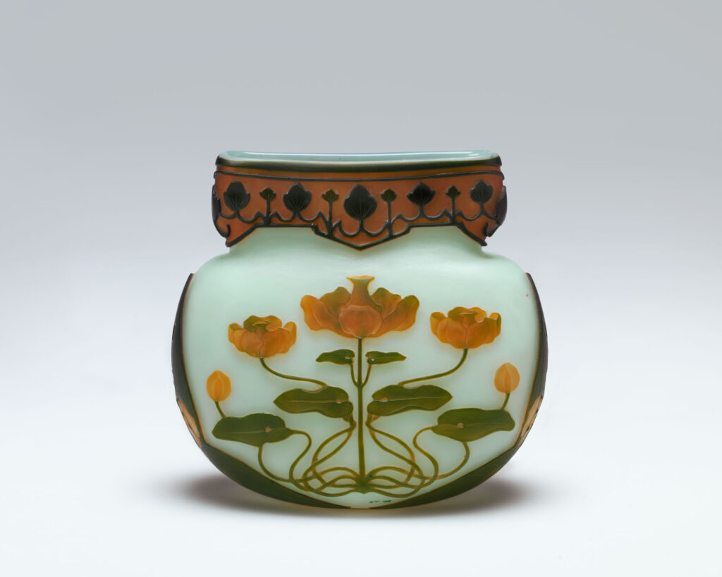 A small vase made by the Sèvres porcelain manufactory in an art nouveau style, with a pale green background decorated with cameo glass waterlilies.