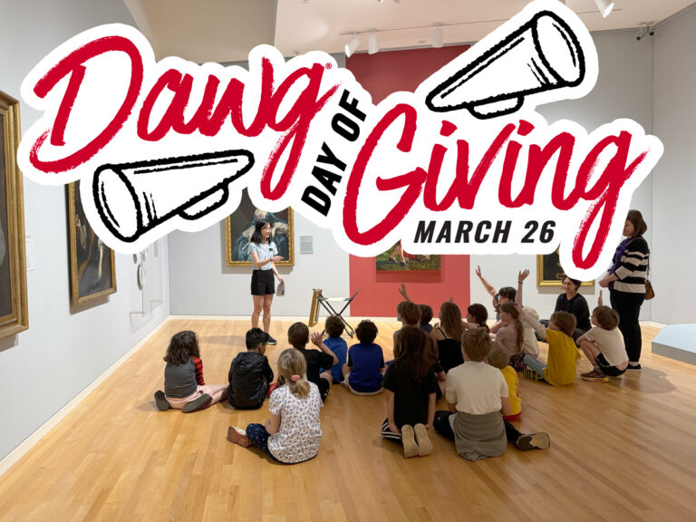 A photograph of a student gallery teacher in the galleries with kids, with the words "Dawg Day of Giving" on top of the photo