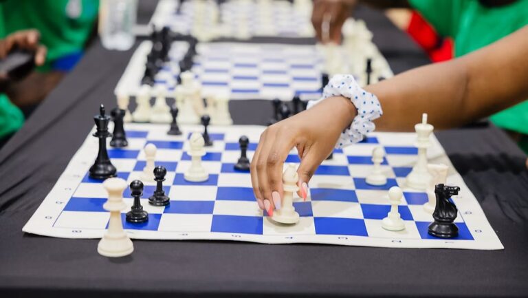 A hand moving a white chess piece