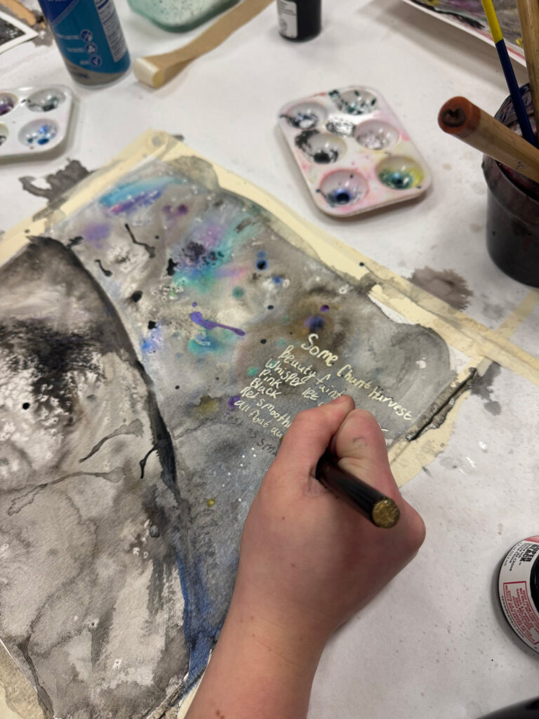 A close-up on someone's hand making art at the museum