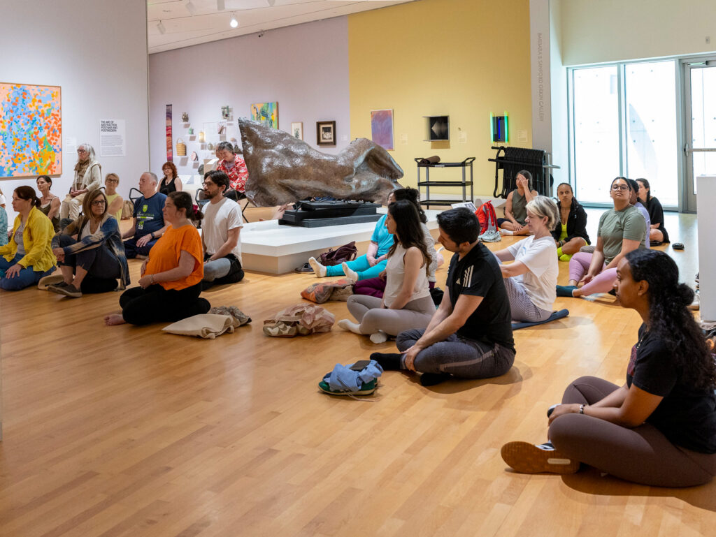 A large crowd doing yoga in the galleries for Sunday Slowdown