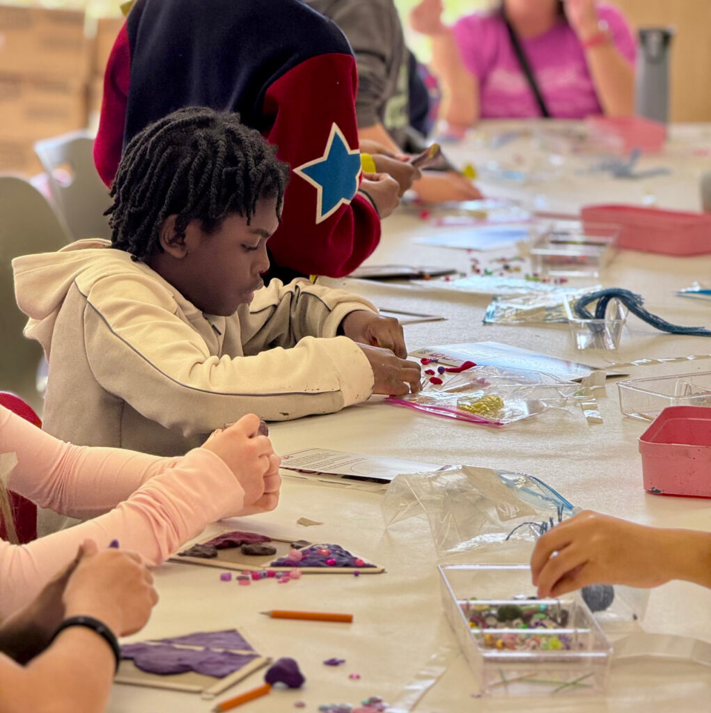 A child making art in the museum’s studio classroom as part of a school tour