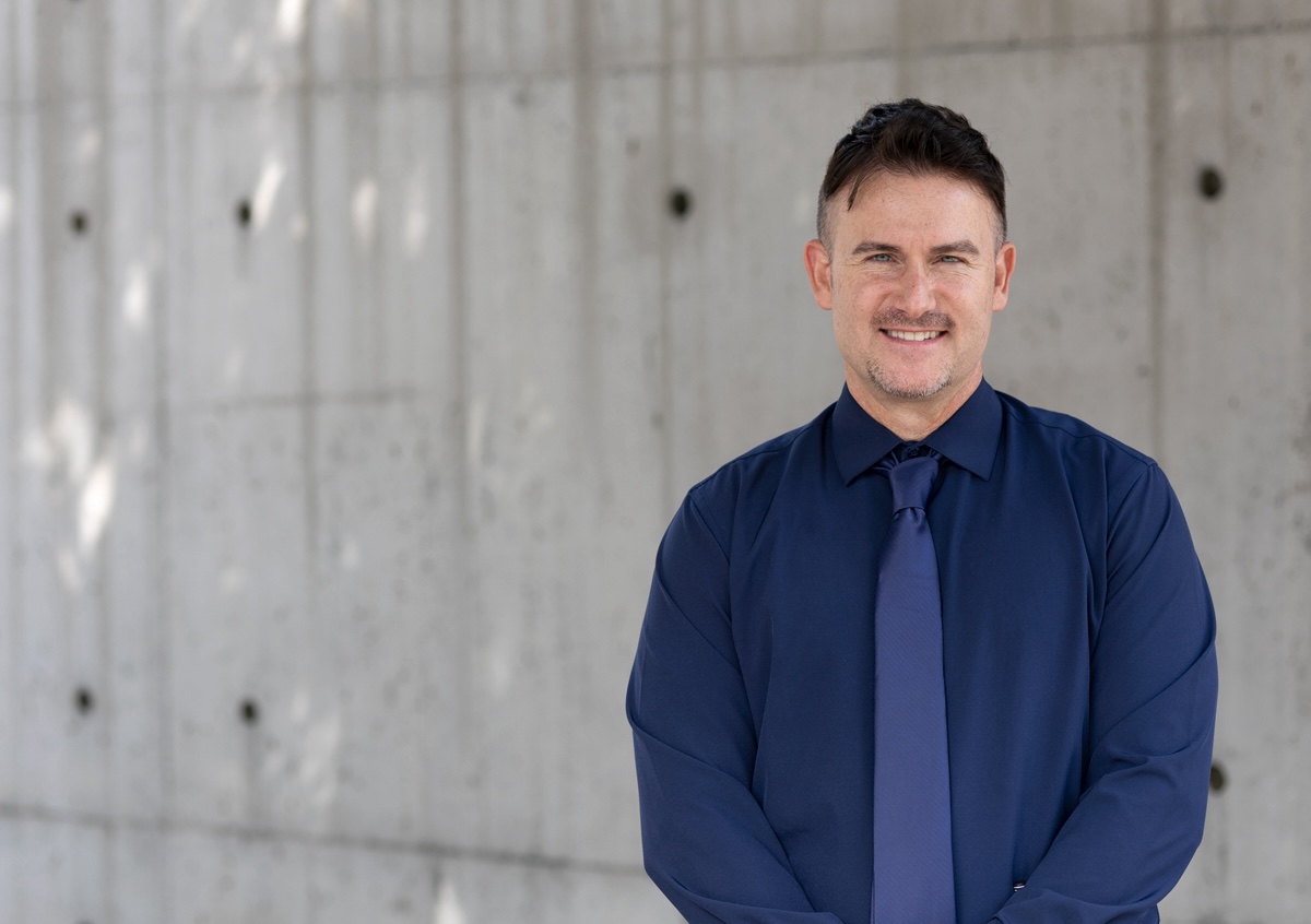Kyle Gallagher standing in front of a concrete wall.