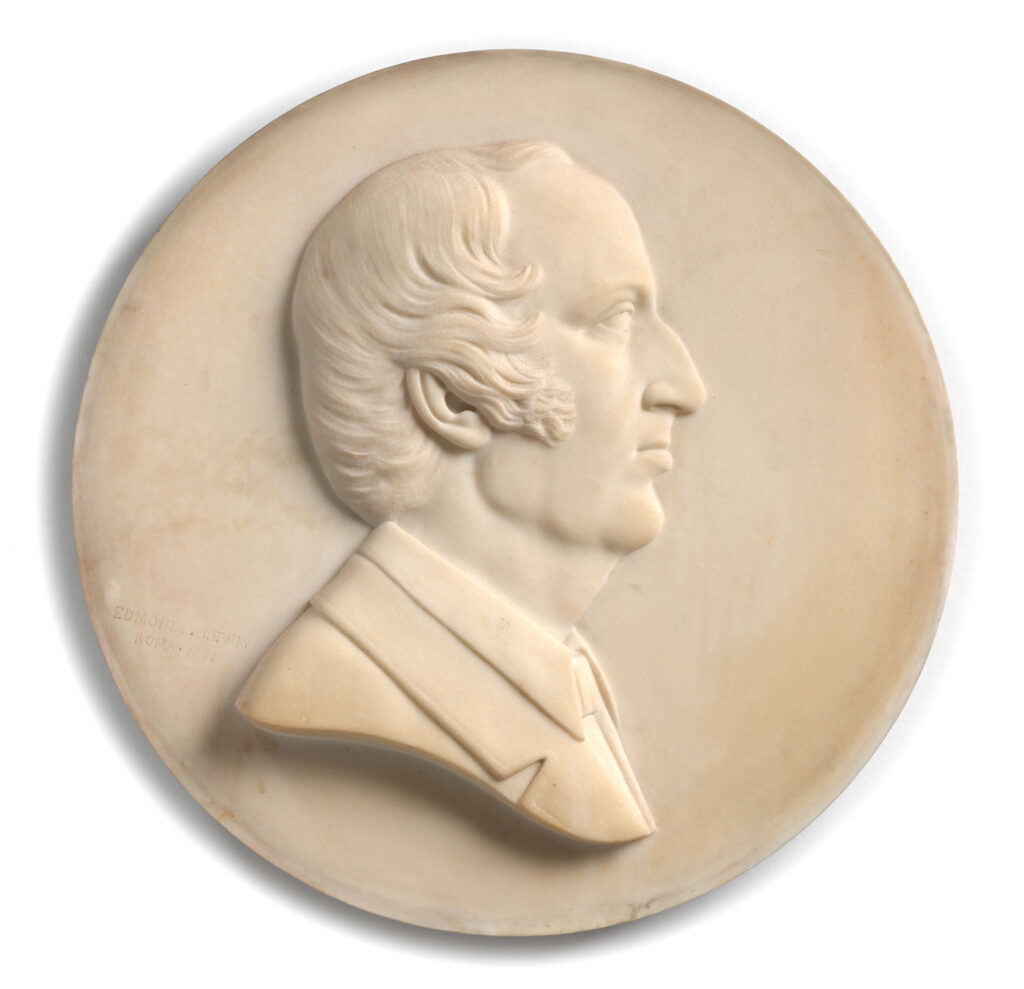 A marble portrait of Wendell Phillips in relief on a circular medallion. He appears in profile, facing our right.