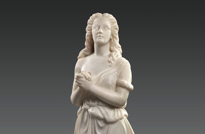 Edmonia Lewis’ marble sculpture of Hagar, the slave of the biblical Abraham and Sarah. She clasps her hands and looks up, her long hair flowing over her shoulders and her loose gown off her right shoulder.