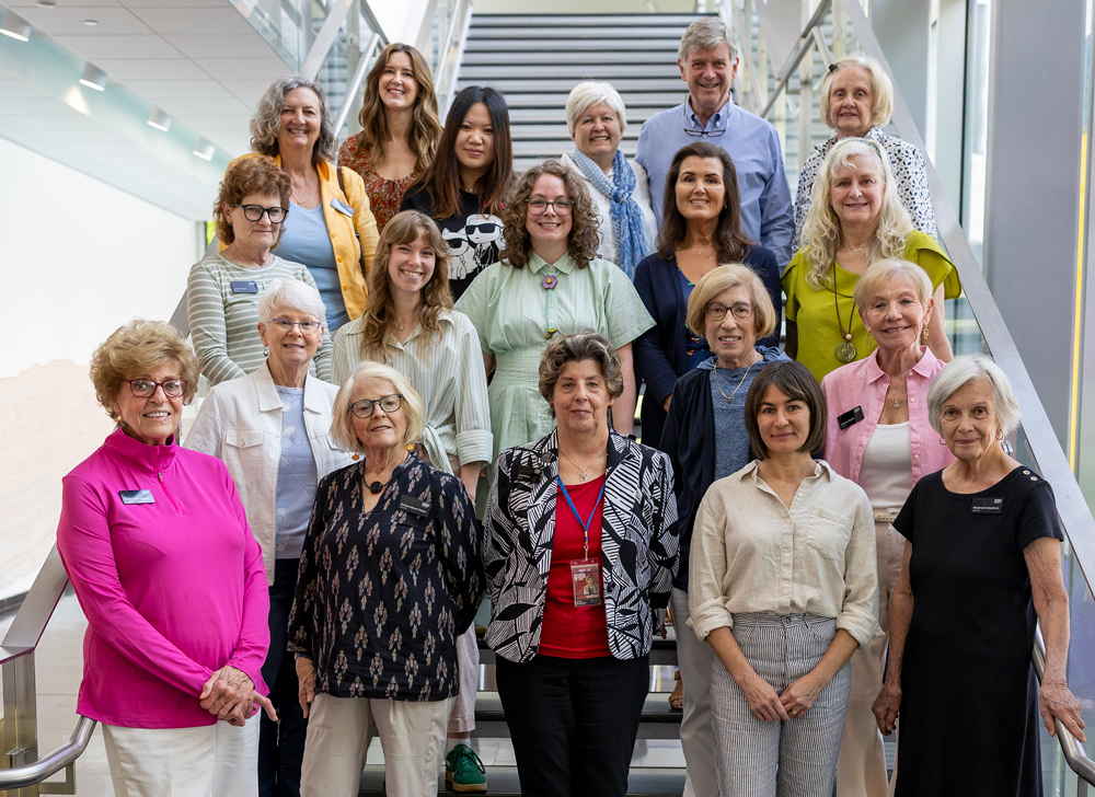 Museum docents posing for a photo on the stairs in the lobby